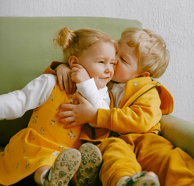Image of young boy kissing a young girl playfully